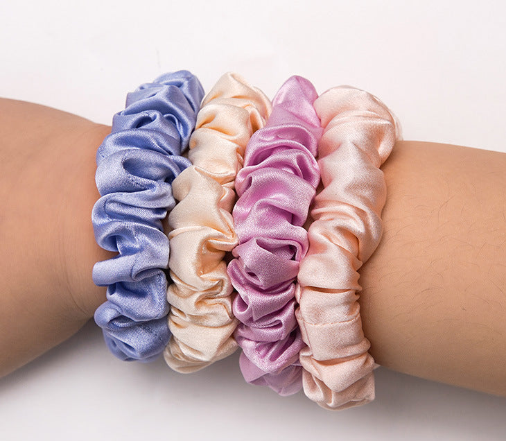 A light - colored 100% silk scrunchie in a woman's hair-4