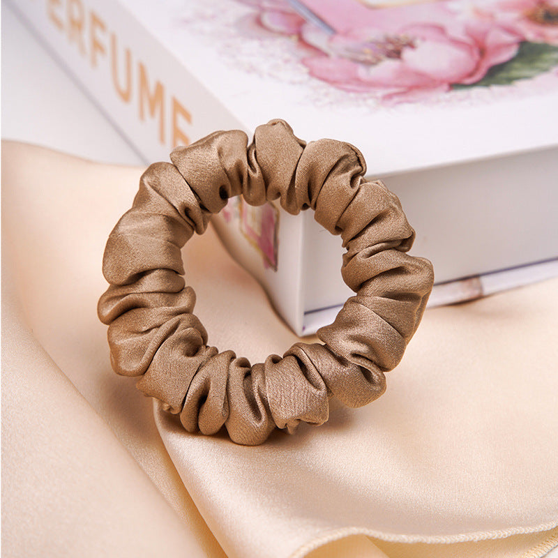A light - colored 100% silk scrunchie in a woman's hair-13