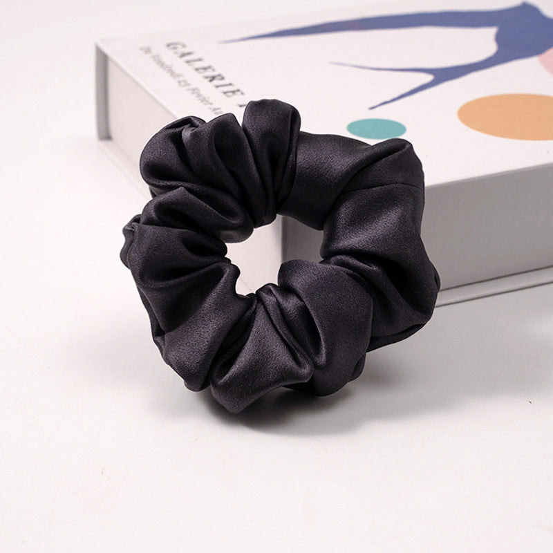 A collection of silk scrunchies in various colors-14