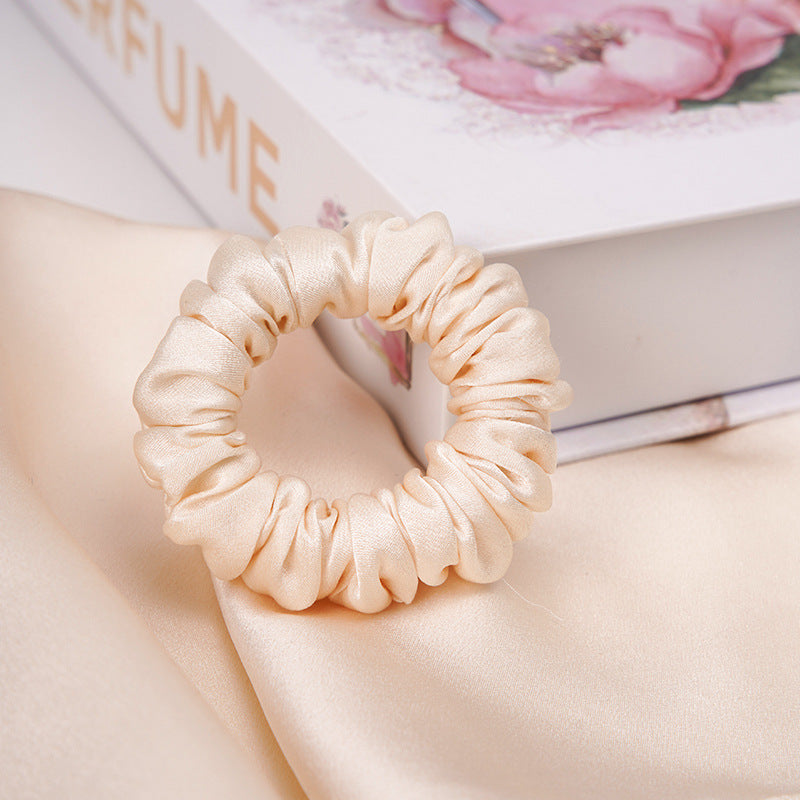 A light - colored 100% silk scrunchie in a woman's hair-14