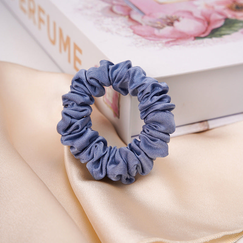 A light - colored 100% silk scrunchie in a woman's hair-12
