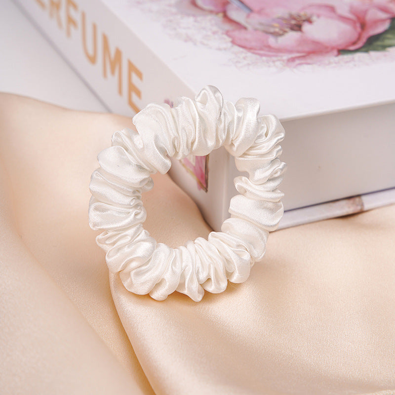 A light - colored 100% silk scrunchie in a woman's hair-7