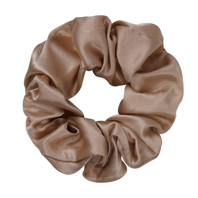 A pastel - pink 100% silk scrunchie worn on a woman's wrist and in her hair-5