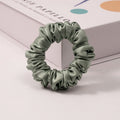 A set of silk scrunchies in various colors including beige, blue, brown, and more-6