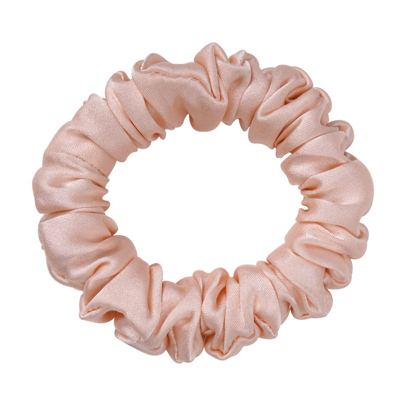 A light - colored 100% silk scrunchie in a woman's hair-5