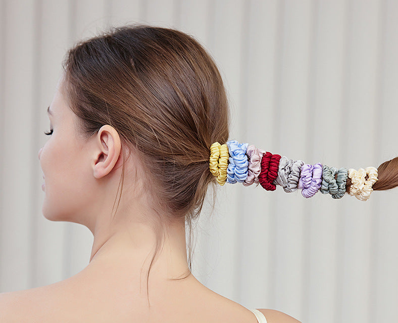 A woman wearing colorful 100% silk scrunchies in her hair and on her wrist-4