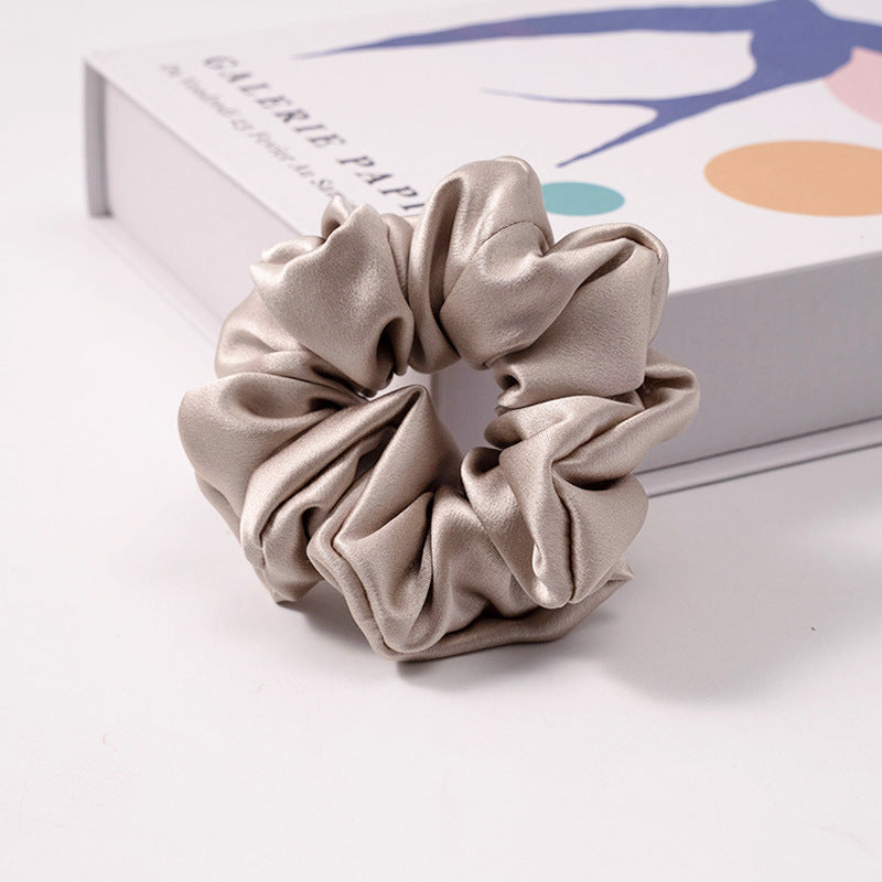 A collection of silk scrunchies in various colors-11