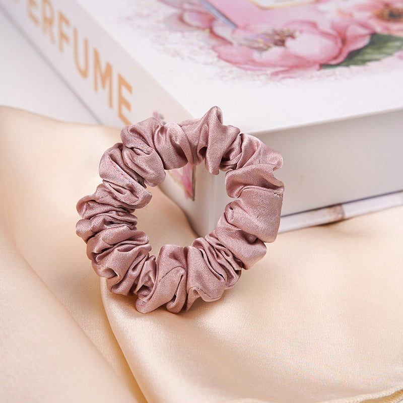 A light - colored 100% silk scrunchie in a woman's hair-15