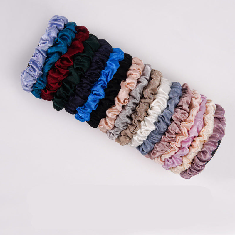 A light - colored 100% silk scrunchie in a woman's hair-3