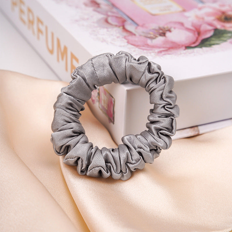 A light - colored 100% silk scrunchie in a woman's hair-9