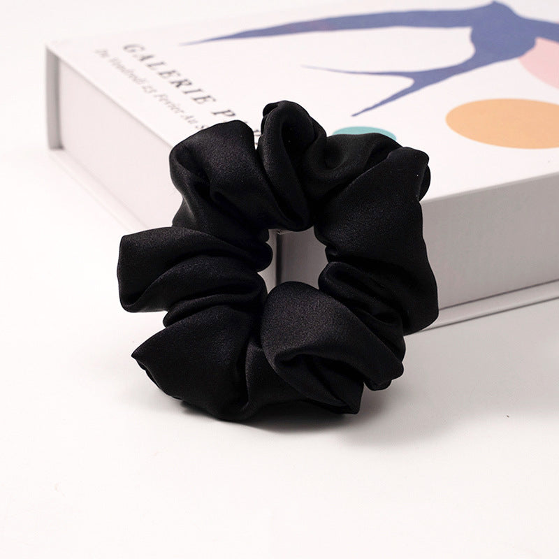 A collection of silk scrunchies in various colors-8