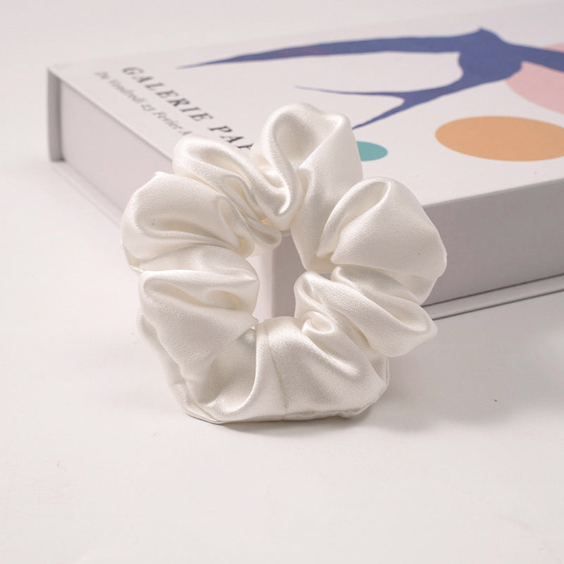 A collection of silk scrunchies in various colors-9