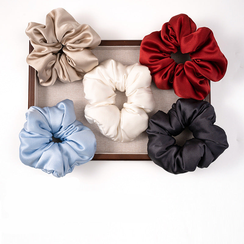 Solid - colored 100% silk scrunchies in beige, light blue, white, red, and black