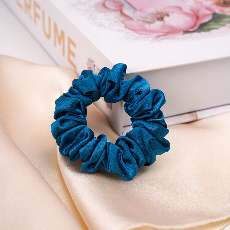 A light - colored 100% silk scrunchie in a woman's hair-17