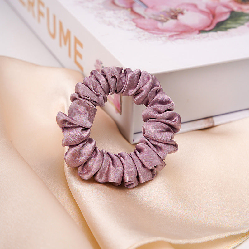A light - colored 100% silk scrunchie in a woman's hair-18