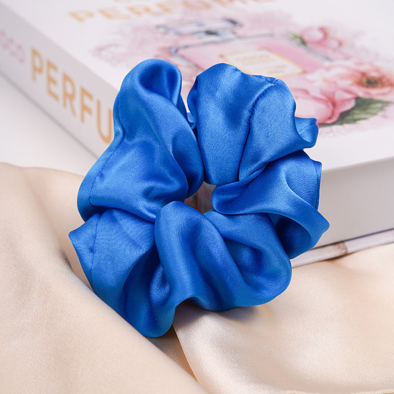 A pastel - pink 100% silk scrunchie worn on a woman's wrist and in her hair-19