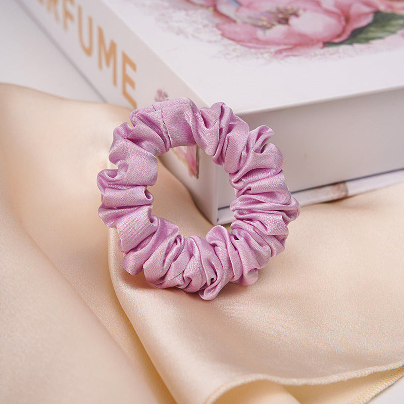 A light - colored 100% silk scrunchie in a woman's hair-19