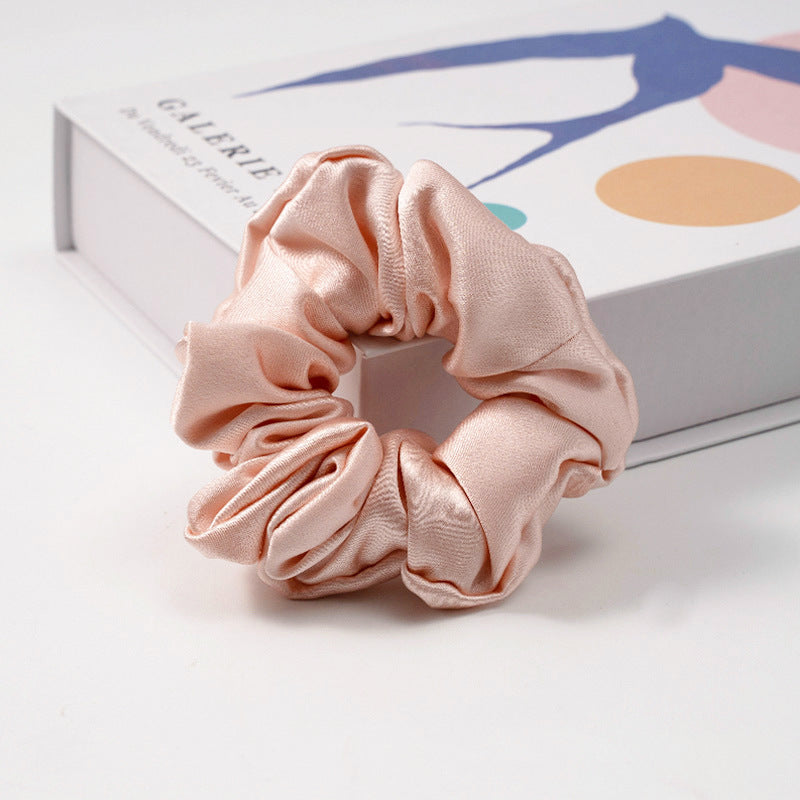 A collection of silk scrunchies in various colors-13
