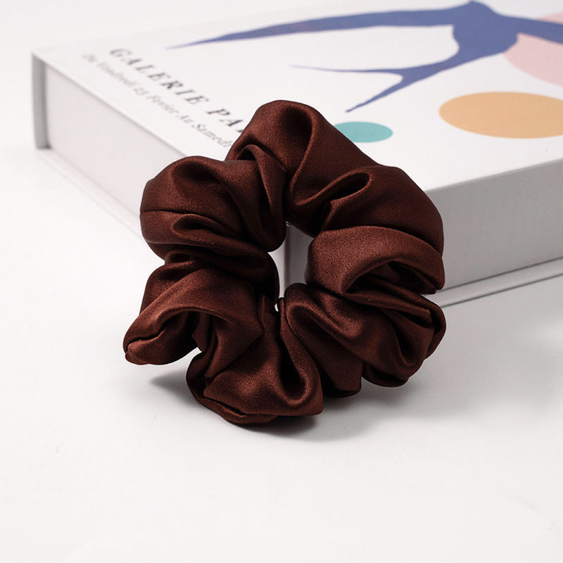 A collection of silk scrunchies in various colors-15