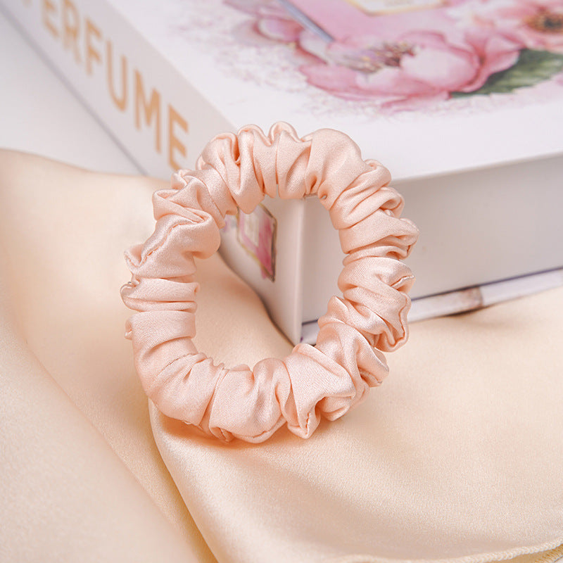 A light - colored 100% silk scrunchie in a woman's hair-8