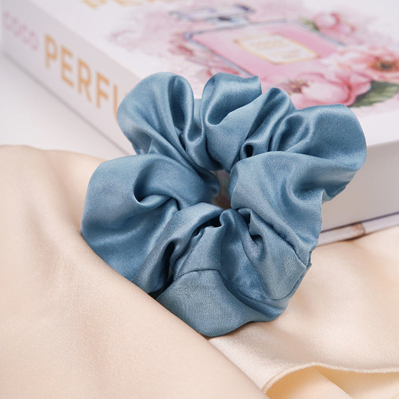 A pastel - pink 100% silk scrunchie worn on a woman's wrist and in her hair-20