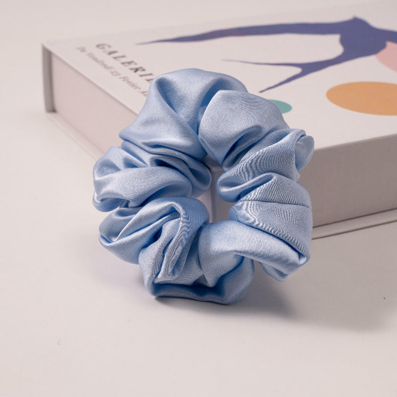 A collection of silk scrunchies in various colors-12
