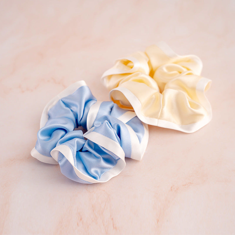 A set of colorful 100% silk scrunchies in beige, black, blue, green, and pink-3