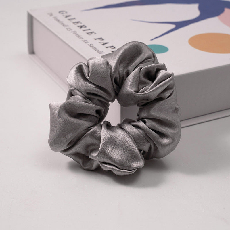 A collection of silk scrunchies in various colors-7