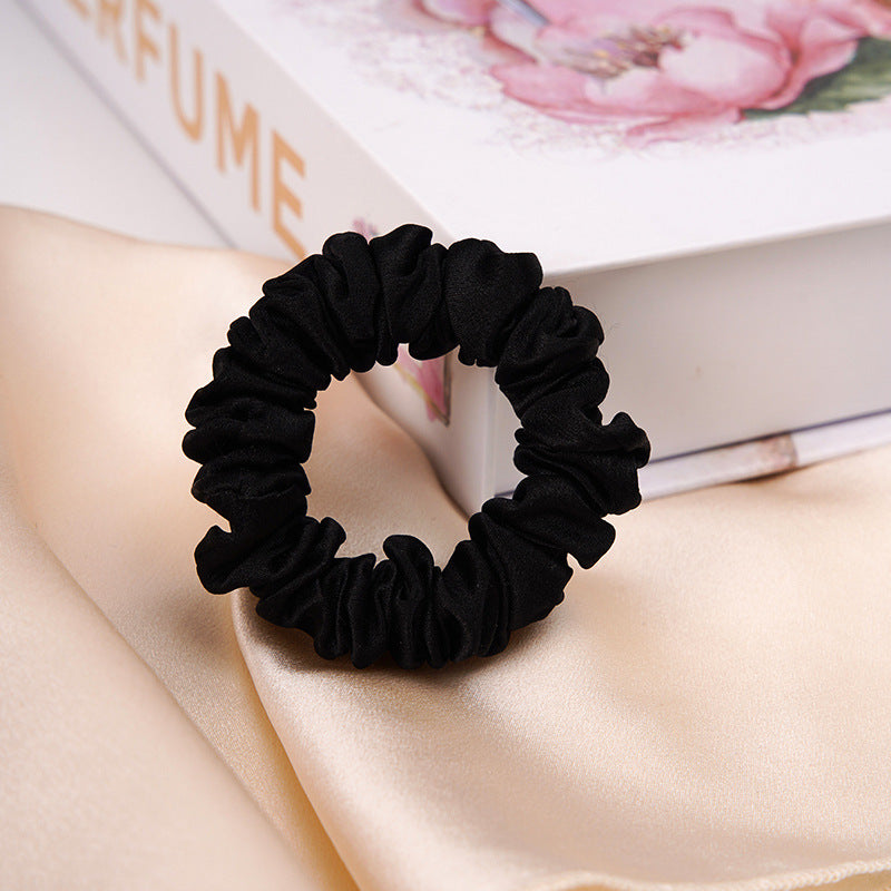 A light - colored 100% silk scrunchie in a woman's hair-6