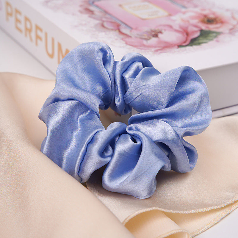 A pastel - pink 100% silk scrunchie worn on a woman's wrist and in her hair-15
