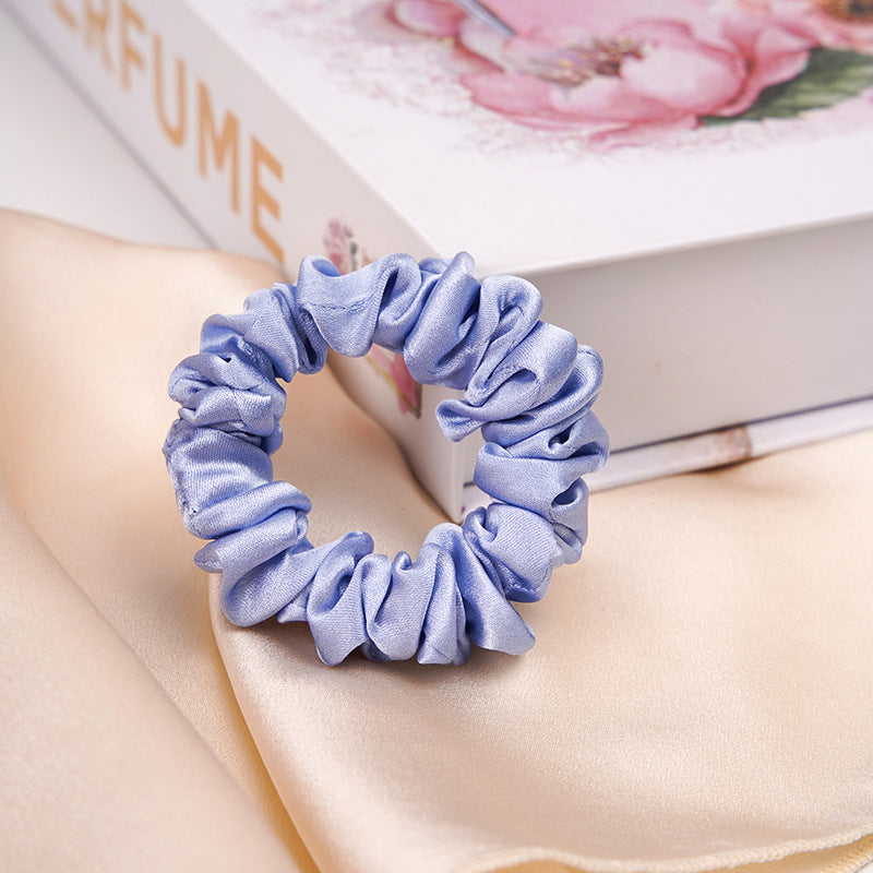A light - colored 100% silk scrunchie in a woman's hair-10